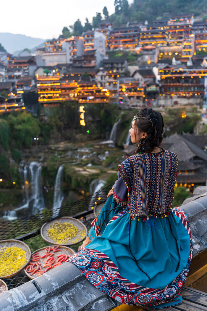 Mujer sentada en ciudad Lijiang